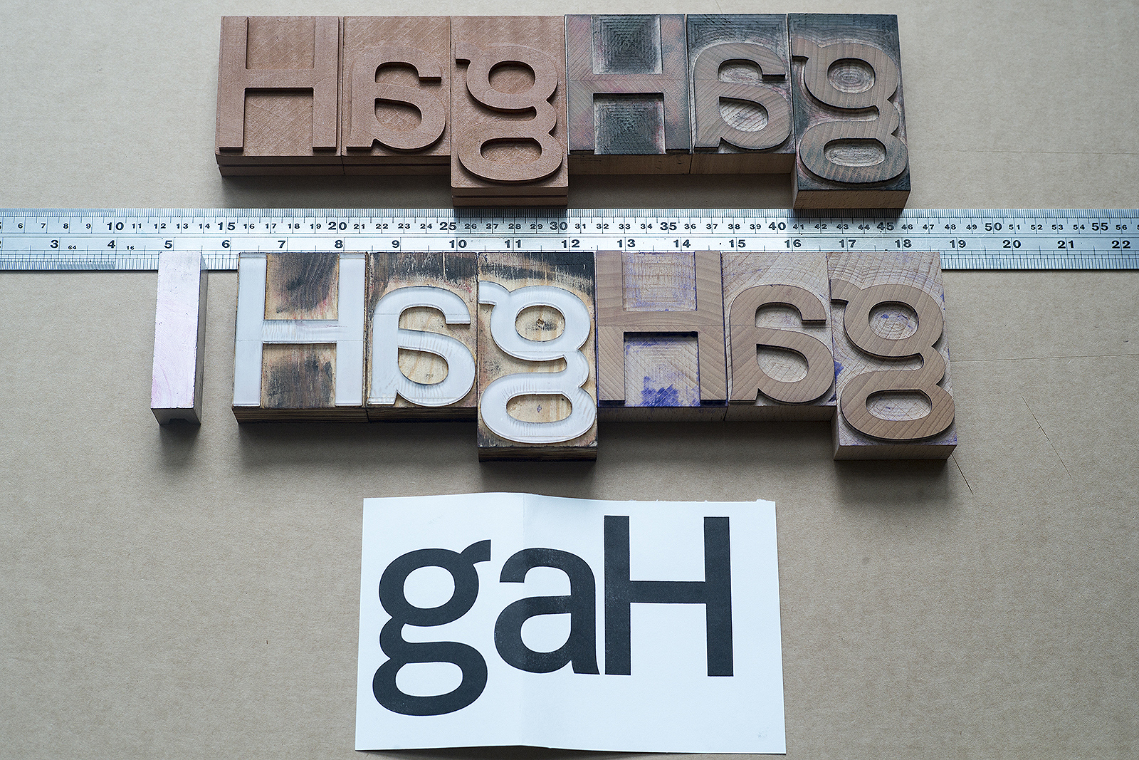 Experimenting with different materials for the letterpress version of FF Real Head. Clockwise from top left: pear wood, maple wood (with wobbly outlines), second run of maple wood (sharp outlines) and acrylic letters, below: a proof from acrylic letters. The aluminum block on the left defines the exact type size of 16cic (72,2044mm) for comparison.